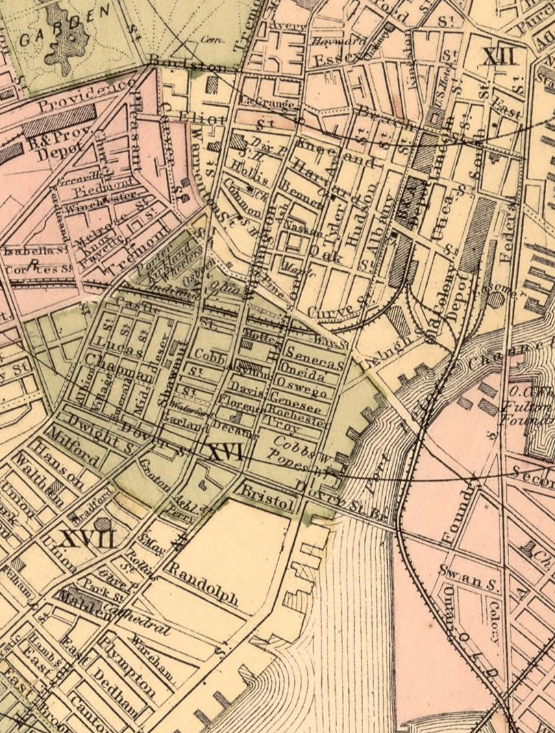 Colored map detail of the area south of Essex Street with street blocks, rail lines, depots and a shoreline at right. Names include Washington, Harrison Avenue and Albany. Colored areas and parallel water lines occur beside the street network.